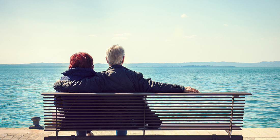 Senior couple on bench by the water