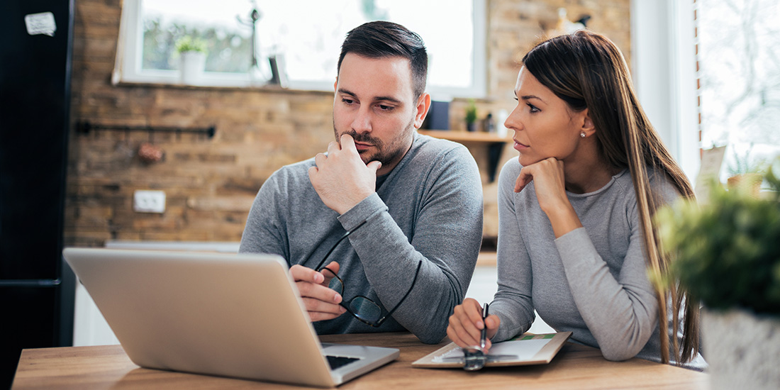 Couple going over bills on a laptop