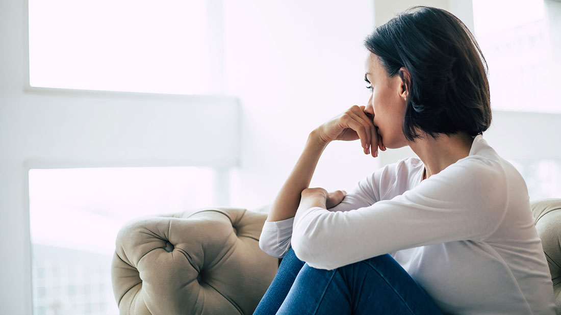Woman worriedly looking out window