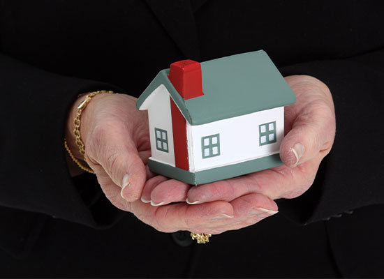 someone holding their hands out to hold a downsized house