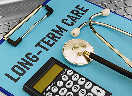 A clipboard with 'LONG-TERM CARE,' a stethoscope, and a calculator