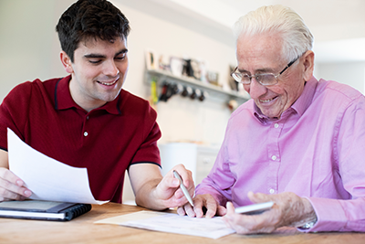 Son helping elderly father with paperwork