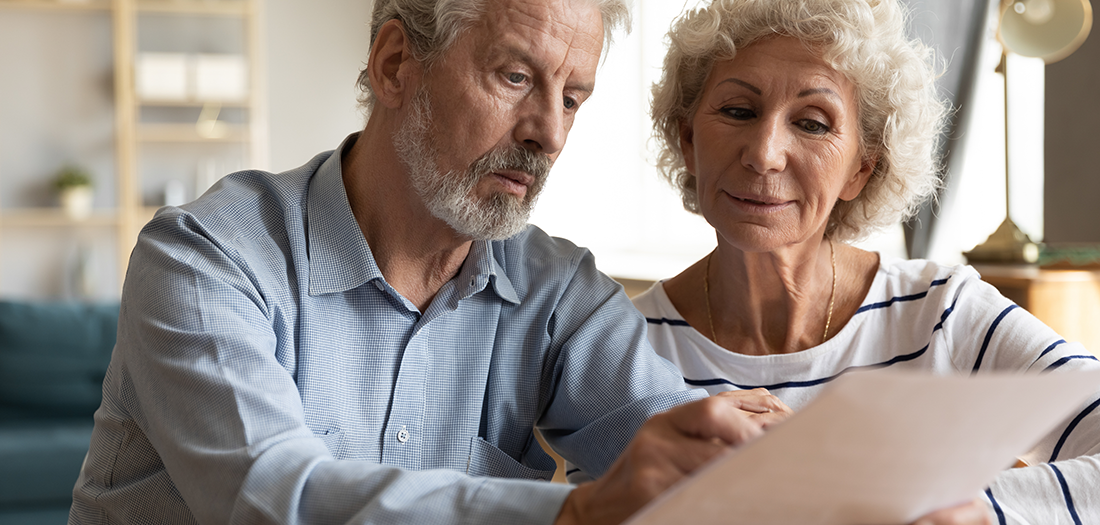 Older couple reviewing a document in their living room