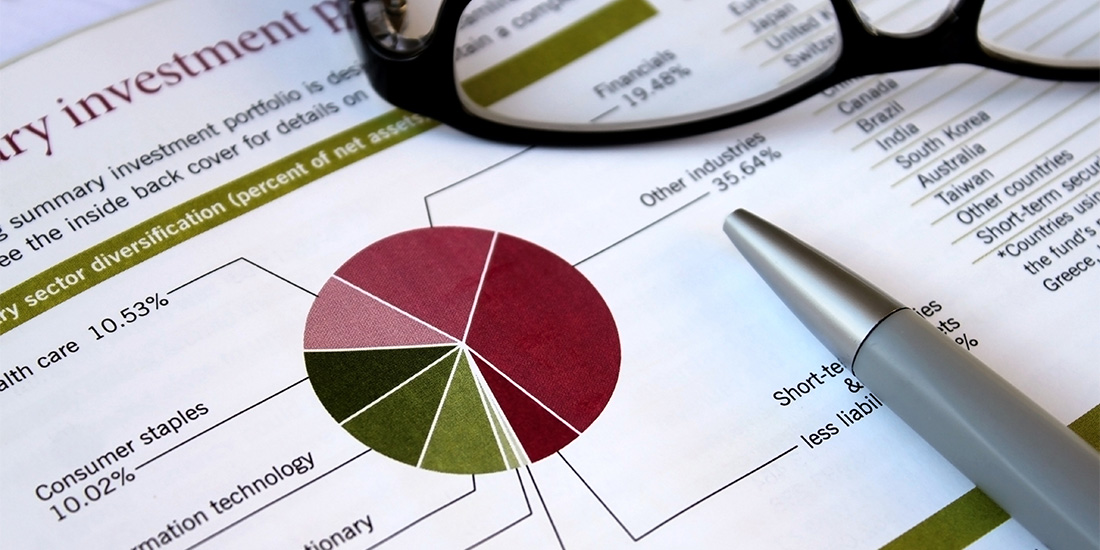 Pen and glasses sitting on top of asset chart