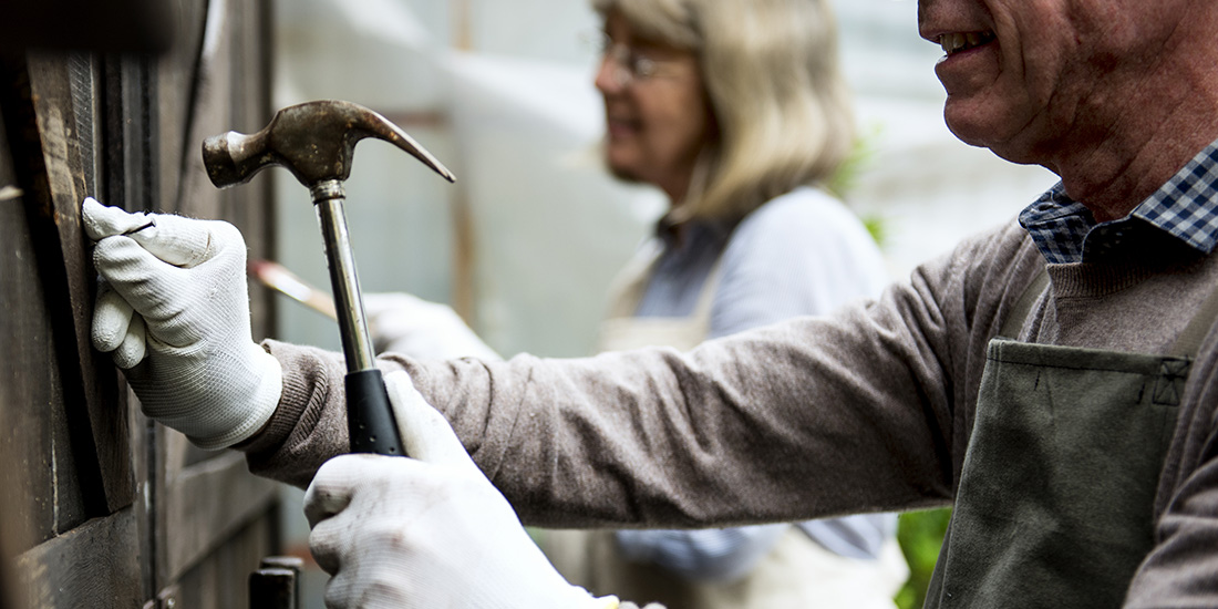 Older Americans improving their home with hammer and paintbrush