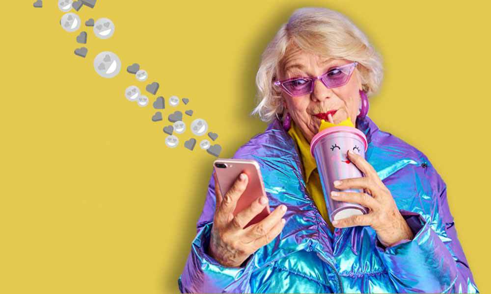 Senior woman checking her social media while drinking from her stylish tumbler