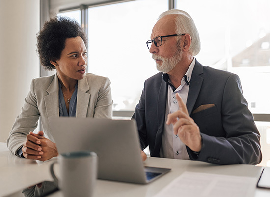 older male and female dressed in business clothes working together