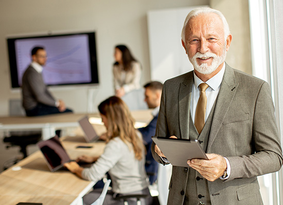 A senior man in a business meeting, illustrating the transition to retirement through phased retirement plans and gradual retirement strategies.