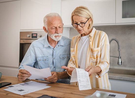 A man and woman examine a paper document together, engaged in discussion and analysis of its contents.