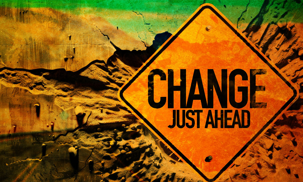 A vibrant road sign reading 'Change Just Ahead' set against a textured, colorful background symbolizing transformation and new opportunities.
