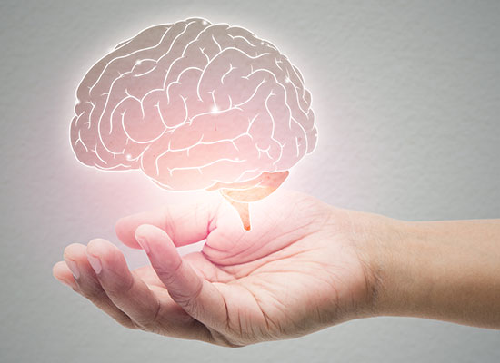 A glowing brain hovers over an open hand, representing the psychological and emotional transition of retirement.