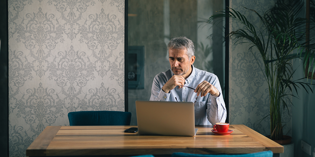A senior man working on a laptop