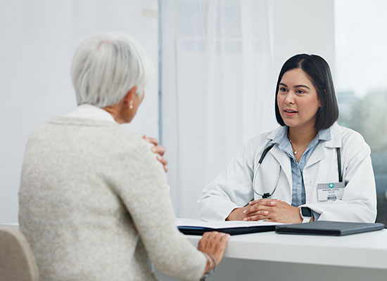 elderly woman speaking to a doctor
