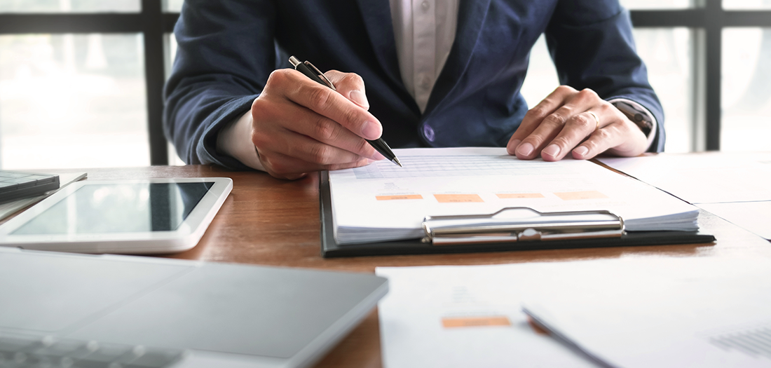 Financial advisor at his desk drawing up documents